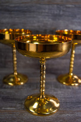 Obraz na płótnie Canvas Three golden antique wine glasses used for decoration.