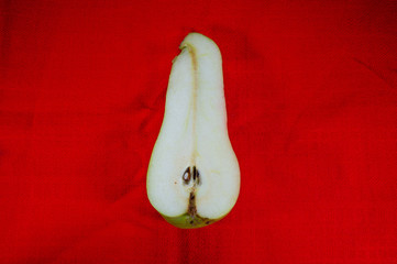 Fresh ripe green pear isolated on a red background.