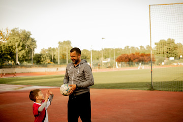 A son and a father are practicing on the court