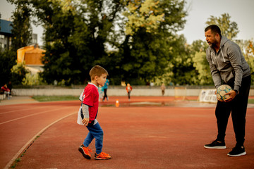 A son and a father are practicing on the court