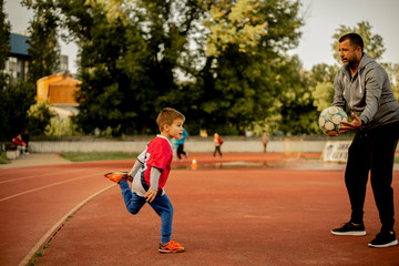 Obraz premium A son and a father are practicing on the court