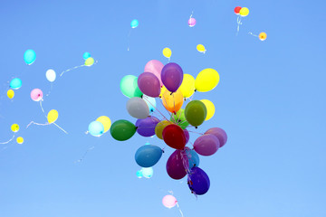 many multicolored balloons flying in the blue sky