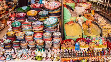 Obraz na płótnie Canvas Traditional Moroccan marrakech market with plates and tajin tagine. Handmade ceramic plates. Arabian colorful ramadan design