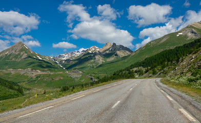 Fototapeta na wymiar Empty asphalt road runs through the idyllic countryside in the French Alps.