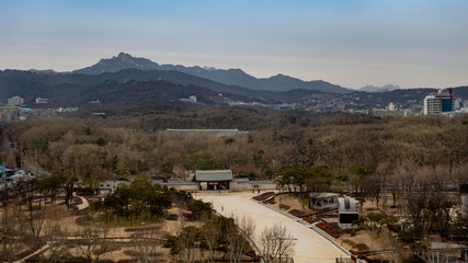 View over UNESCO world heritage listed Jongmyo Shrine in winter, with mountains in the background, as seen from the rooftop of the Sewoon MakerCity Plaza in the Jongno district of Seoul, South Korea