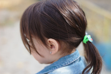 closeup portrait of little cute emotional girl with pigtails in a denim jacket