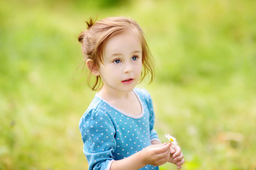 Cute toddler girl outdoors portrait in summer day. Charming child.