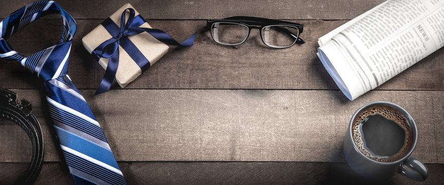  Tie, Belt, And Gift Box With Reading Glasses, Newspapers, And Coffee On Wooden Table - Fathers Day Concept