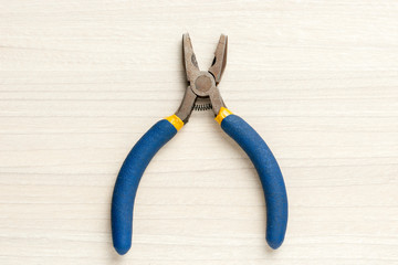 pliers at wooden background. top view.