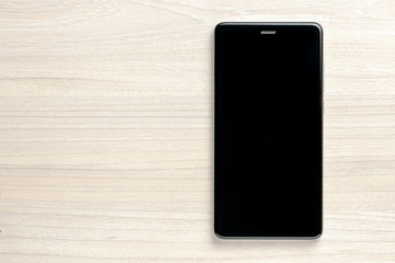 smartphone at wooden desk background. template for design. empty and minimalistic.