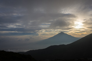 Fototapeta premium Warm morning sunrise on Tebing Soni with view of mount Cikuray. Beautiful landscape of mount Papandayan. Papandayan Mountain is one of the favorite place to hike on Garut.