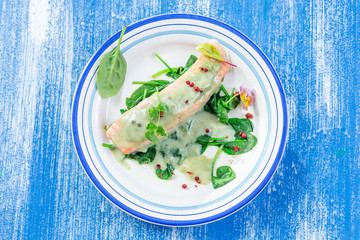 Steamed cooked salmon and vegetables spinach, sorrel sauce. Lunch, fillets.