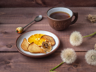 Fruit chips, healthy snack with morning coffee in a brown ceramic mug on a wooden rustic tray