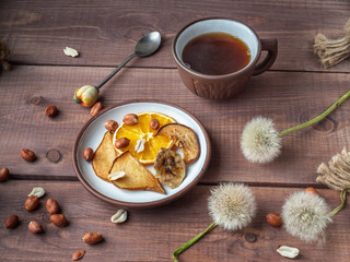 Delicious fruit chips and peanut nuts for fitness girls with a cup of coffee