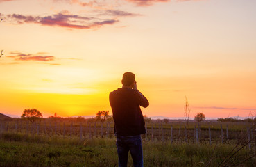 man takes a sunset photo