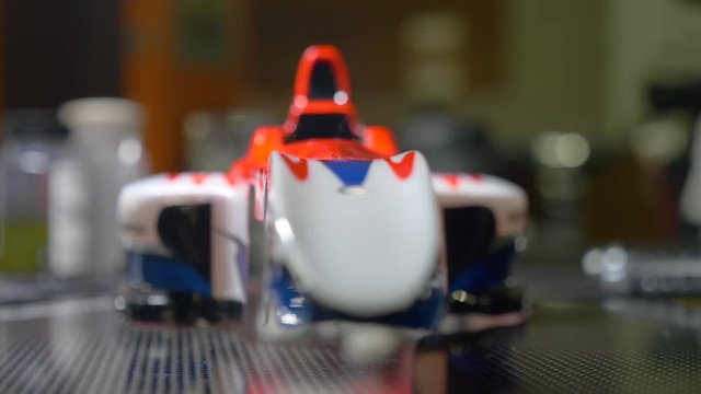 Close up and chenge of focus of an f1 rc car body during an rc car race.