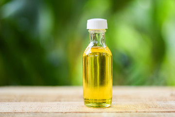 Sesame oil in glass bottles on wooden and nature green