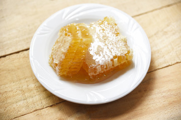 Fresh honey - Close up of yellow sweet honeycomb slice on white plate natural healthy food