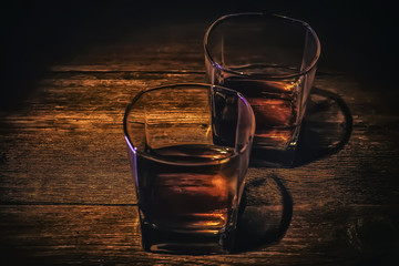 whiskey in a glass on a dark wooden background.
