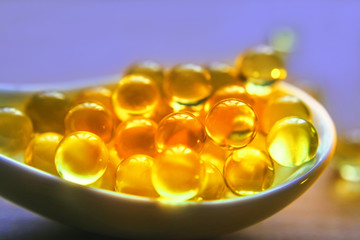 medical capsules in a porcelain spoon.