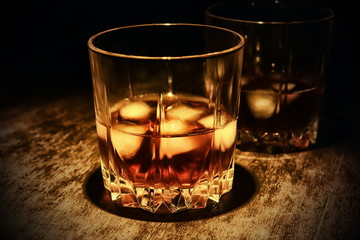 whiskey in a glass on a dark wooden background.