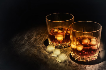 whiskey in a glass on a dark wooden background.