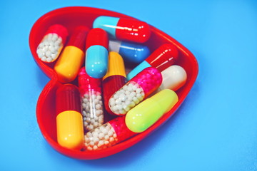 medical capsules in a heart shaped container.