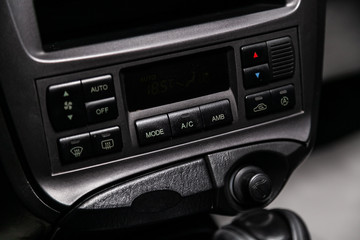 Сlose-up of the car  black interior:  dashboard, adjustment of the blower, air conditioner and other buttons.