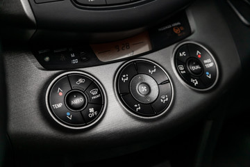 Fototapeta premium Сlose-up of the car black interior: dashboard, adjustment of the blower, air conditioner, accelerator handle and other buttons.