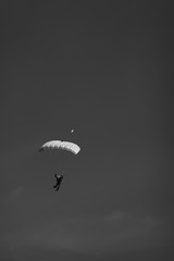Skydiver with a high-speed canopy parachute on a background of a dark sky. Black and white.