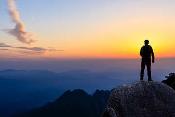 Fototapeta premium Young happy backpacker on top of a mountain enjoying valley view