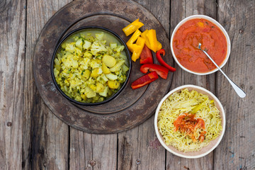 Homemade Indian vegetarian lunch with basmati rice, spicy tomato sauce, cauliflower sabji - vegetables stew.