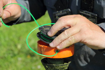 Lawn mower fills the coil with new line in the rotor of trimmer - maintenance of garden tools