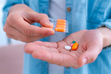 Vitamins and tablets for well-being and disease treatment. Medicine woman taking pills for...