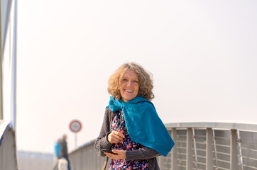 Smiling woman in blue scarf on the bridge