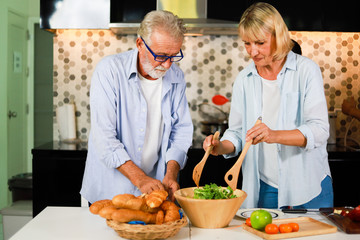 Senior couple Man and woman cooking in kitchen happy mood
