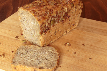 Fresh seeded bread on the table. Square loaf with pumpkin, sunflower, and flax seeds.