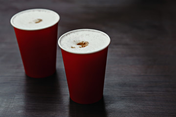 Hot paper cups of coffee in in a street cafe