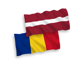National vector fabric wave flags of Latvia and Romania isolated on white background. 1 to 2 proportion.