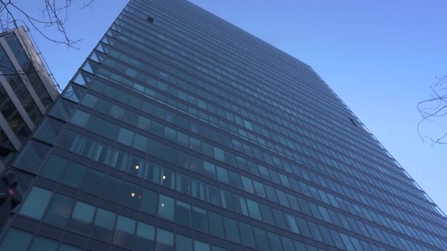 Looking up from the ground toward the top of the Kista Science Tower. Sharp angles and walls of glass in the design of this modern skyscraper towering above other buildings in the area.