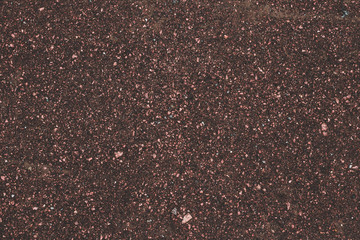 Dark brown asphalt road texture. Abstract background of small pebbles, road surface. Brown pattern of granite stone. Art design, tinsel, sparkles. Roadway backdrop, textile texture, highway.