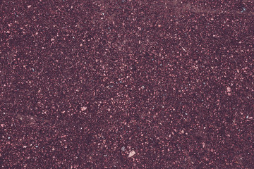 Abstract purple background of small pebbles, asphalt surface. Pink pattern of granite stone. Art design, tinsel, sparkles. Texture backdrop, road texture.