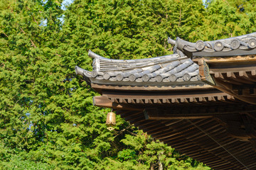 Close up of traditional Japanese temple or shrine roof with ancient bell, Japan.
