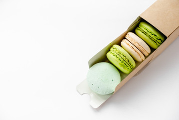 Assorted macaroons in craft paper box flat lay.white table background. top view Copyspace horizontal
