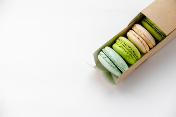 Assorted macaroons in craft paper box flat lay.white table background. top view Copyspace horizontal