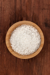 Fototapeta na wymiar A bowl of sea salt, shot from the top on a dark rustic wooden background with a place for text