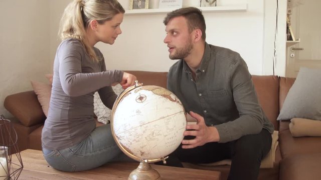 Couple looking at globe and planning their next journey