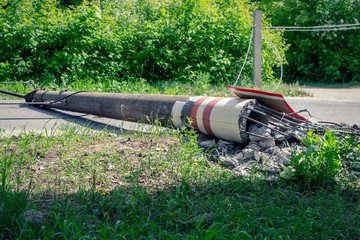 Electric pole. Broken broken wood power line post with electrical components on the ground after...