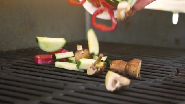 Vegetables falling onto BBQ grill in slowmotion