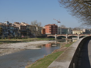 Fototapeta na wymiar Parma riverside panorama. Panorama along Parma riverside near Ponte di Mezzo bridge.